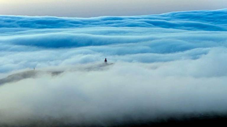 Picture taken On June 29, 2025 with a drone, shows a rare roll cloud, a huge horizontal cloud advancing from the horizon towards the beaches of the Atlantic Ocean during the heatwave near Cabo da Roca, southwestern Portugal. - AFPPIX