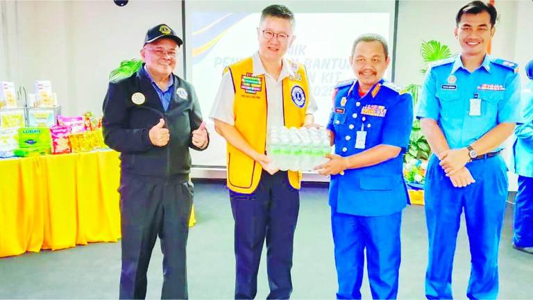 Tan presenting a carton of drinking water to Rohaizat. – P. CHANDRA SAGARAN/THESUN