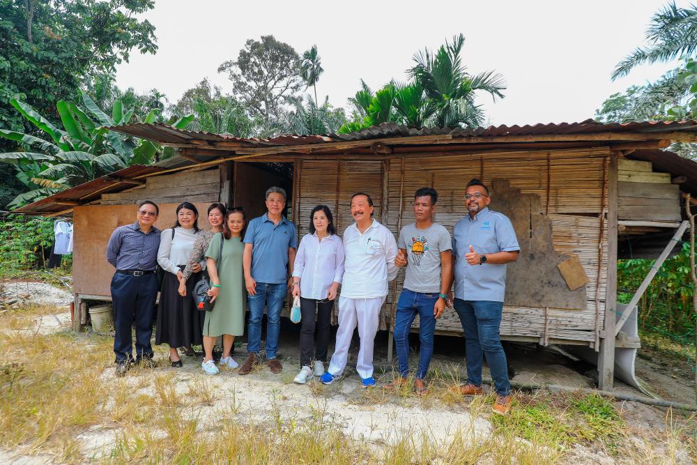 $!Tan and his entourage outside one of the old bamboo huts the Orang Asli used to live in. – AMIRUL SYAFIQ/THESUN