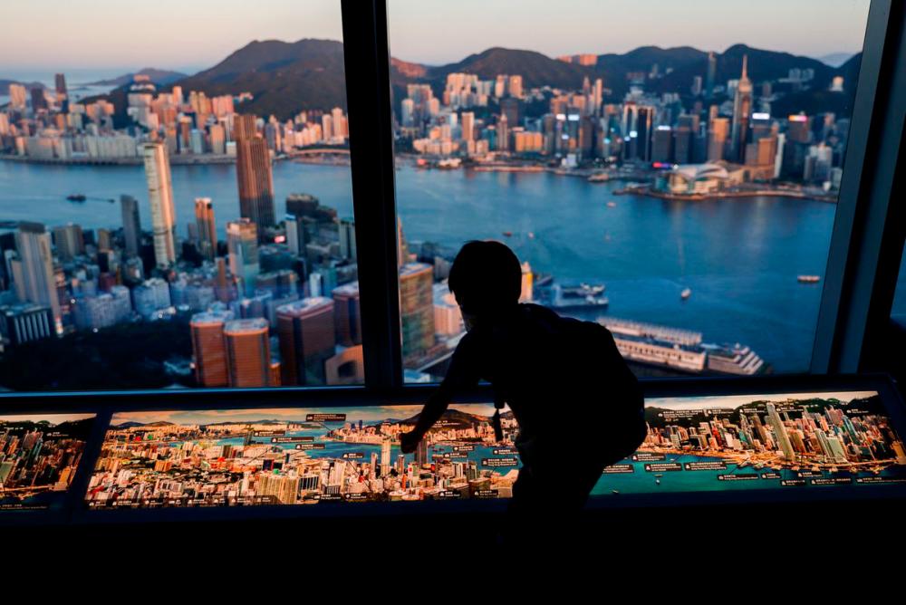 A child plays in front of skyline buildings, in Hong Kong, China, July 13, 2021. REUTERSPix