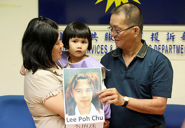 Grandparents Loi Lee Ping (L) and Lee Kok Hoe (R) and Low Xin Er, 5, hold up a portrait of her mother, seeking her return during a press conference at the MCA Public Service and Complaints Department on March 13, 2019. — Sunpix by Norman Hiu