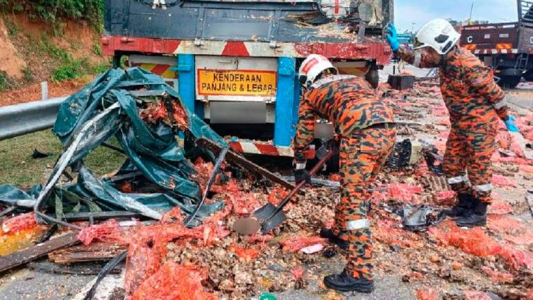 Fire and rescue personnel clearing the accident site. - Pic courtesy of Perak Fire and Rescue Department