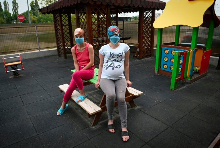 Two women are pictured at a centre for victims of domestic violence and trafficking in Romania. — AFP