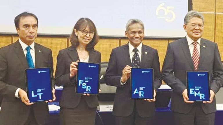 From left: BNM deputy governors Adnan Zaylani Mohamad Zahid and Jessica Chew, Abdul Rasheed and deputy governor Marzunisham Omar displaying Bank Negara’s reports.