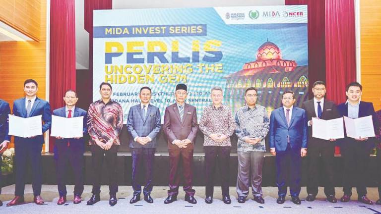 Shukri (sixth, left) and Liew (seventh, left) at the Mida Invest Series Perlis event in Mida KL Sentral today.