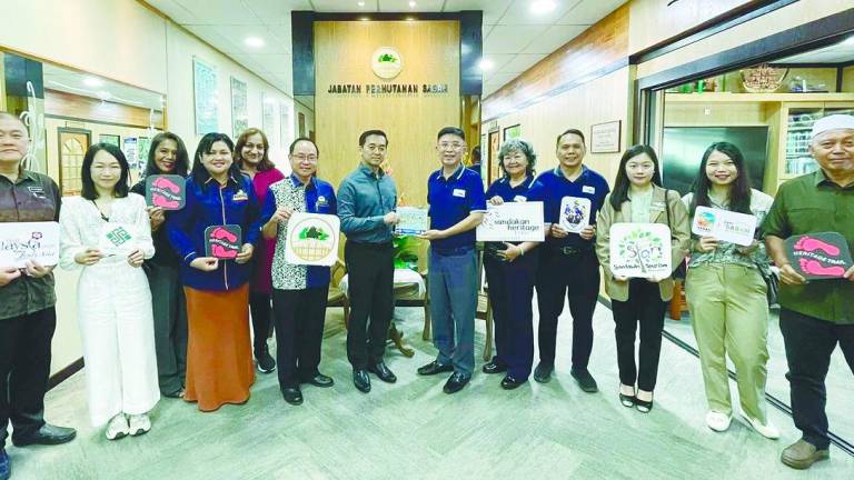 Lai (sixth from right) presents a memento to Kugan during the courtesy call.