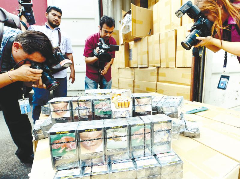 Press photographers taking pictures of part of 40,000 cartons of illegal cigarettes seized at the KL International Airport. — Bernama