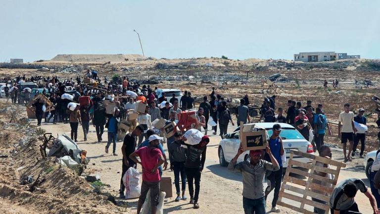 Displaced Palestinians walk along a road to receive humanitarian aid packages from a US-backed foundation in Rafah in the southern Gaza Strip on June 5, 2025. - AFPPIX