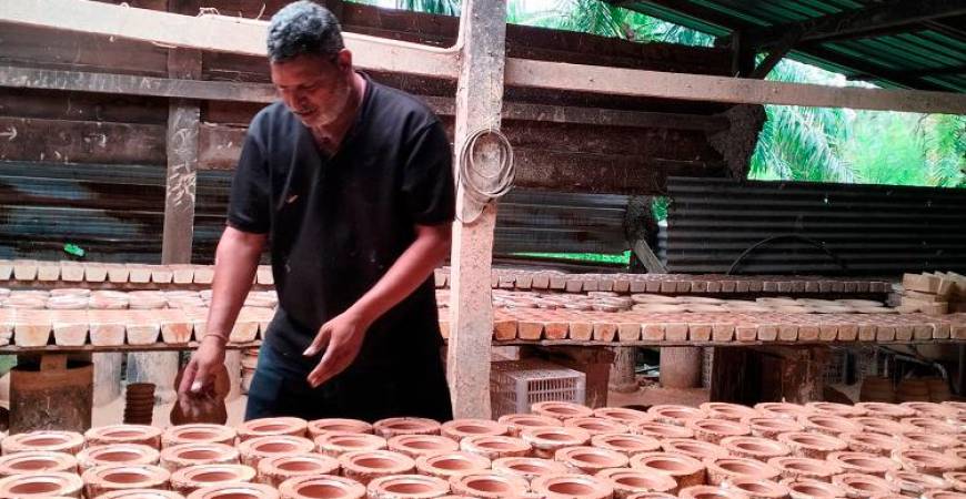 Reguraj checking the quality of the claypots.