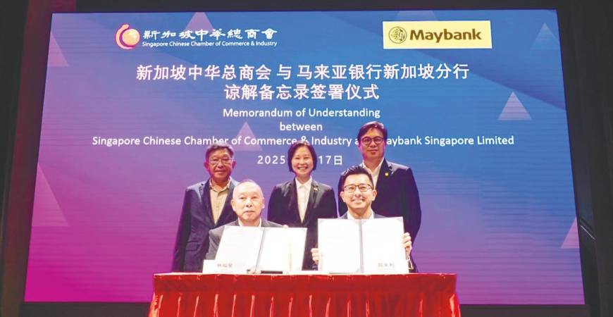 Displaying the signed MoU are SCCCI vice-president Lim Hock Chee (left) and Maybank Services head of community financial services Adam Tan. Standing, from left, are Kho, Gan and Maybank Singapore head of global banking Chong Wee Yeat.