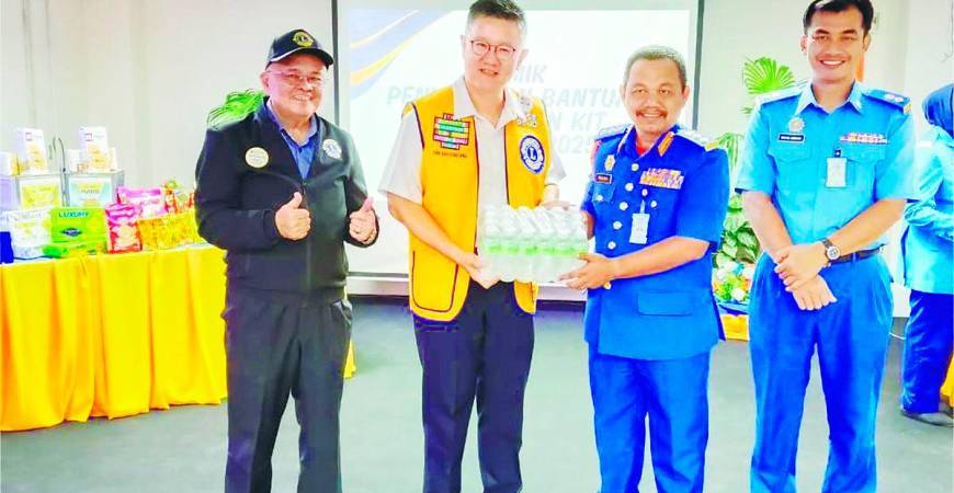 Tan presenting a carton of drinking water to Rohaizat. – P. CHANDRA SAGARAN/THESUN