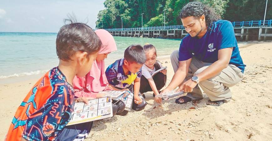 Alvin teaching the children the value of respecting the environment and its surroundings, especially marine life on Tioman.