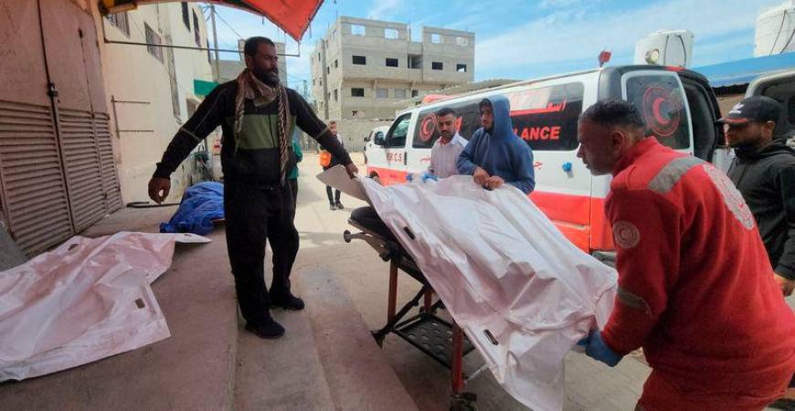 Mourners and a paramedic move the body of a Palestinian, killed in an Israeli strike - REUTERSpix