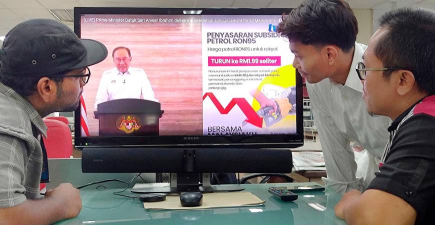 A group of man watches televisions as Malaysian Prime Minister Anwar Ibrahim addresses the nation during a live telecast. - SYED AZAHAR SYED OSMAN THESUN