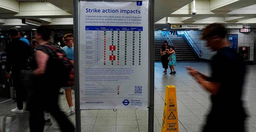 An information board warns commuters and rail users of the impact to London Underground services during a planned strike action by members of the Railway workers’ union RMT, at Victoria Station in London on September 7, 2025. - CARLOS JASSO / AFP