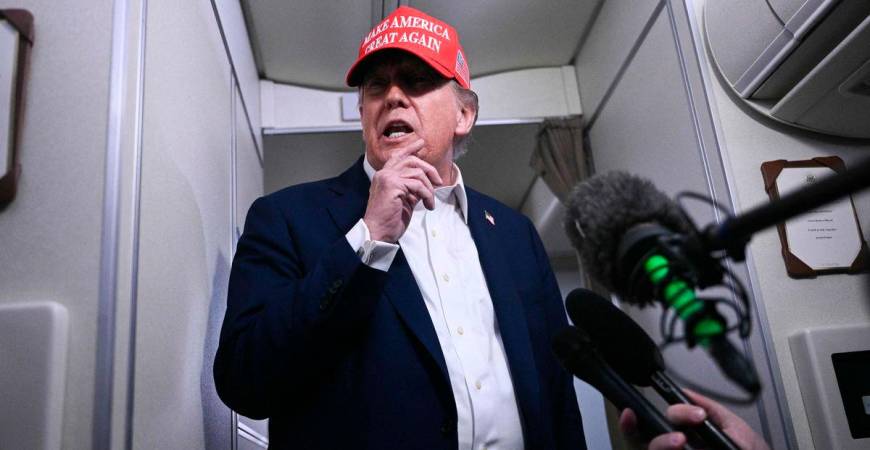 US President Donald Trump speaks to journalists aboard Air Force One after departing Joint Base Andrews, Maryland on his way to Bedminster - Brendan SMIALOWSKI / AFPPix