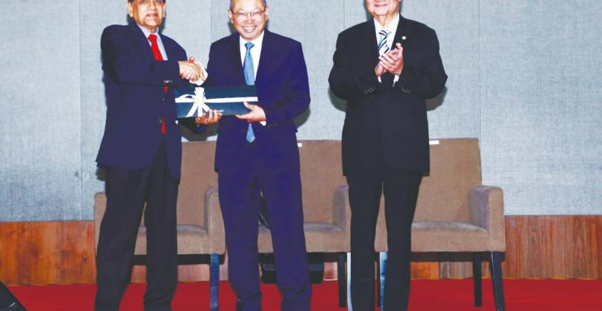 Economic Club of Kuala Lumpur chairman and KSI deputy chairman Datuk Seri Mohamed Iqbal Rawther (left) presents a souvenir to Abdul Wahid while Yeoh looks on.