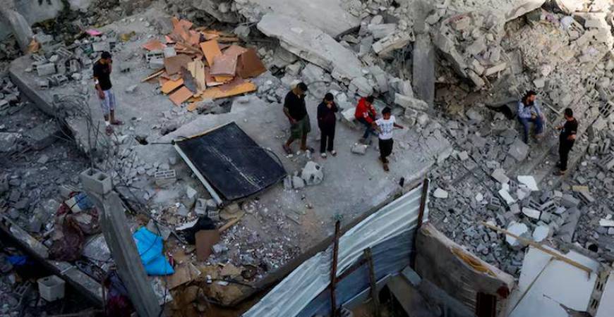 Palestinians inspect the site of an Israeli strike on a house, in Khan Younis in the southern Gaza Strip, May 3, 2025. REUTERS/Hatem Khaled