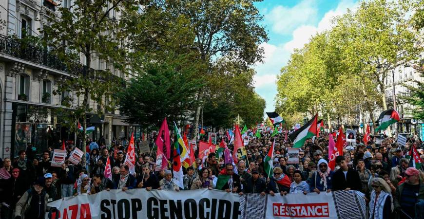Demonstrators hold a banner reading “Gaza, stop genocide, restistance antisionist, anticolonialist, urgence palestine” during a rally in solidarity with Palestinians and to protest against the interception by the Israeli army of the Global Sumud Flotilla, in Paris on October 4, 2025. (Photo by Anna KURTH / AFP)