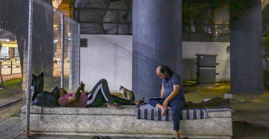 Homeless people who seek shelter under a bridge near the Pasar Seni LRT Station are among those who received packets of nasi bungkus. For Abbe (inset), the motivation comes from faith. – ADAM AMIR HAMZAH THESUN