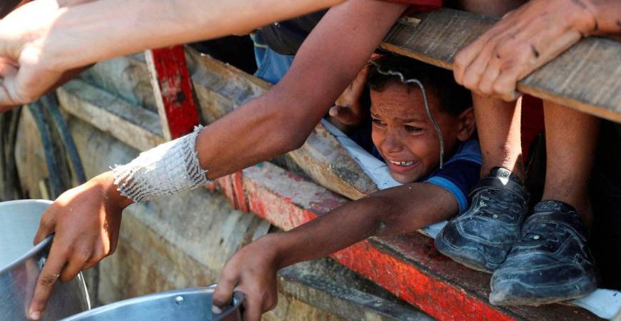 A Palestinian child waits to receive food from a charity kitchen, amid a hunger crisis, in Gaza City. Reuters/TPX Images of the Day