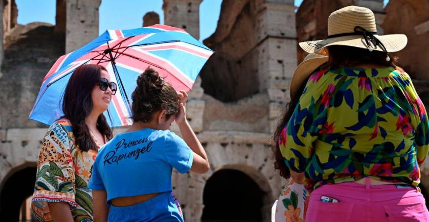 Tourists shelter from the sun with umbrellas near the Colosseum in Rome, on July 14, 2023, as Italy is hit by a heatwave. AFPPIX
