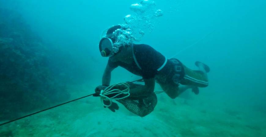 This photo taken on October 2, 2020 shows Moken fisherman Sanam Changnam hunting for fish off the coast of the southern Thai island of Phuket. The COVID-19 coronavirus has wrought havoc across the world, but for Thailand’s “sea gypsies” it has brought welcome respite from the threat of mass tourism. / AFP / Lillian SUWANRUMPHA