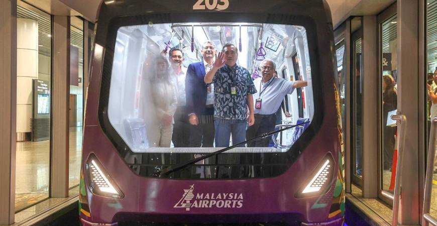 Loke, accompanied by Mohd Izani (second from left), taking an aerotrain ride along with members of the media at KLIA Terminal 1 yesterday. – BERNAMApix