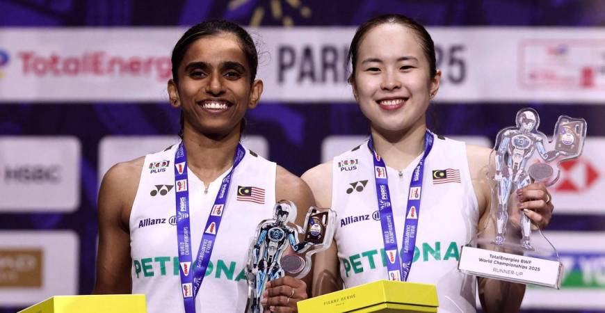 Pemenang pingat perak dari Malaysia, Thinaah Muralitharan dan Pearly Tan, meraikan kejayaan di atas podium bersama pingat dan trofi mereka selepas perlawanan akhir beregu wanita di Kejohanan Badminton Dunia BWF yang berlangsung di Arena Adidas, Paris, pada 31 Ogos 2025. (Foto oleh Thibaud MORITZ / AFP)