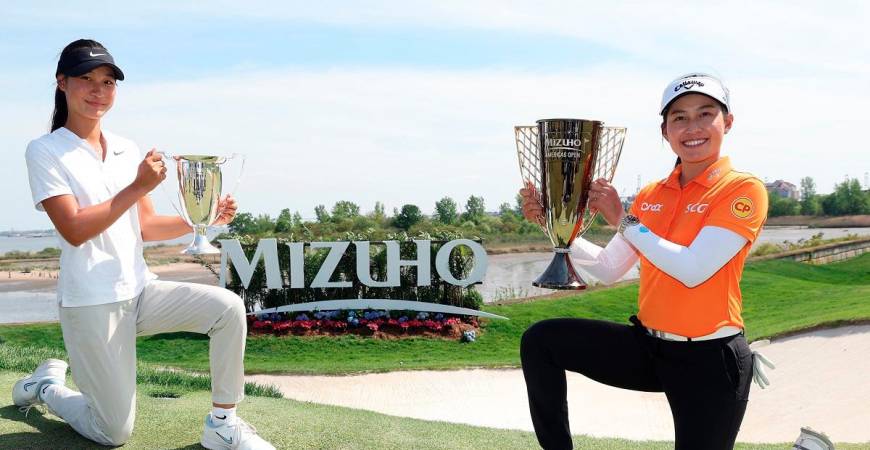 Low amateur Aphrodite Deng (left) and tournament winner Jeeno Thitikul pose with their trophies after the Mizuho Americas Open 2025. – Getty Images