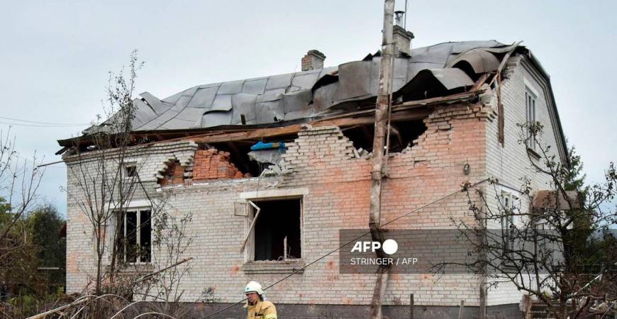 A Ukrainian rescuer walks in the courtyard of a destroyed house following an air attack in Lapaivka, Lviv region on October 5, 2025, amid the Russian invasion of Ukraine. (Photo by STRINGER / AFP)