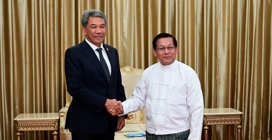 This handout photo taken and released on October 9, 2025 by the Myanmar Military Information Team shows Myanmar’s military chief Min Aung Hlaing (R) shaking hands with Malaysia’s Foreign Minister Mohamad Hasan (L) during a meeting in Naypyidaw. -AFP PHOTO / MYANMAR MILITARY INFORMATION TEAM