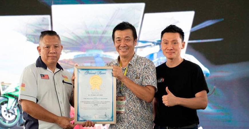 Goy (left) and Tan (far right) receive certificates from the Malaysian Book of Records.