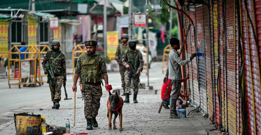 Indian paramilitary soldiers with a sniffer dog patrol at a marketplace in Srinagar on May 10, 2025. - AFPPIX