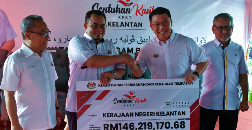 Menteri Perumahan dan Kerajaan Tempatan Nga Kor Ming (dua, kanan) menyampaikan replika cek kepada Exco Kerajaan Tempatan, Perumahan, Kesihatan dan Alam Sekitar Hilmi Abdullah (dua, kiri) pada Program Sentuhan Kasih Kementerian Perumahan dan Kerajaan Tempatan (KPKT) di Kampung Baru Cina hari ini. - BERNAMA