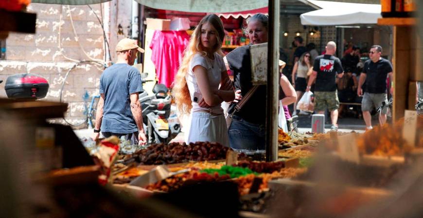 People walk past and observe market stalls selling Middle Eastern produce, in Tel Aviv, Israel, June 27, 2025. - REUTERSPIX