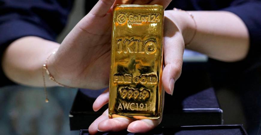 FILE PHOTO: A staff member shows a one-kilogram gold bar at the Galeri 24 gold and jewellery shop in Jakarta, Indonesia, October 9, 2025. REUTERS/Ajeng Dinar Ulfiana/File Photo