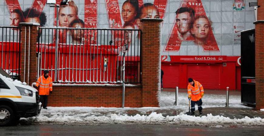 Workers clear snow outside the stadium before the match. Photo: Reuters