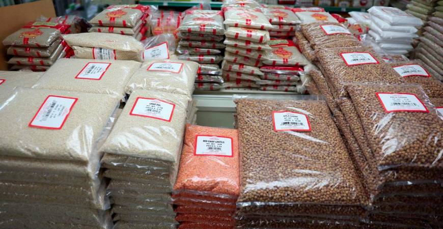 Bags of dal, lentils, chana, and other groceries imported from India are displayed for sale at Farm Fresh grocery as small businesses face tariffs, rising costs, and supply chain uncertainties in the Little India neighborhood of Artesia, California on August 7, 2025. - AFPPIX