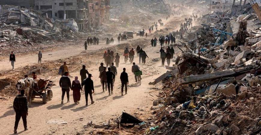 People walk past the rubble of collapsed buildings along Saftawi street in Jabalia in the northern Gaza Strip - REUTERSpix