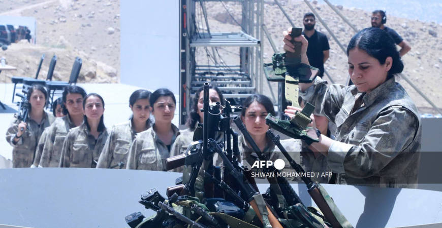 Fighters with the Kurdistan Workers’ Party (PKK) line up to put their weapons into a pit during a ceremony in Sulaimaniyah, in Iraq’s autonomous Kurdistan region, on July 11, 2025. - AFP