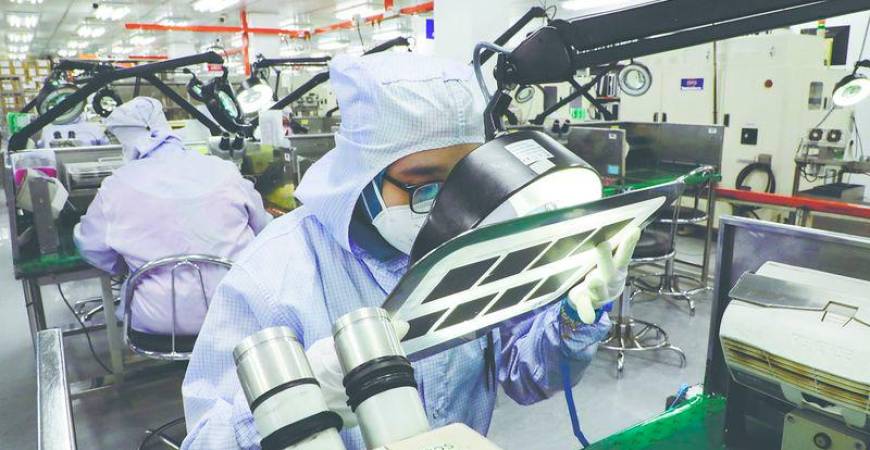 A worker inspects semiconductor chips at a chip packaging firm in Ipoh, Malaysia. – REUTERSPIC