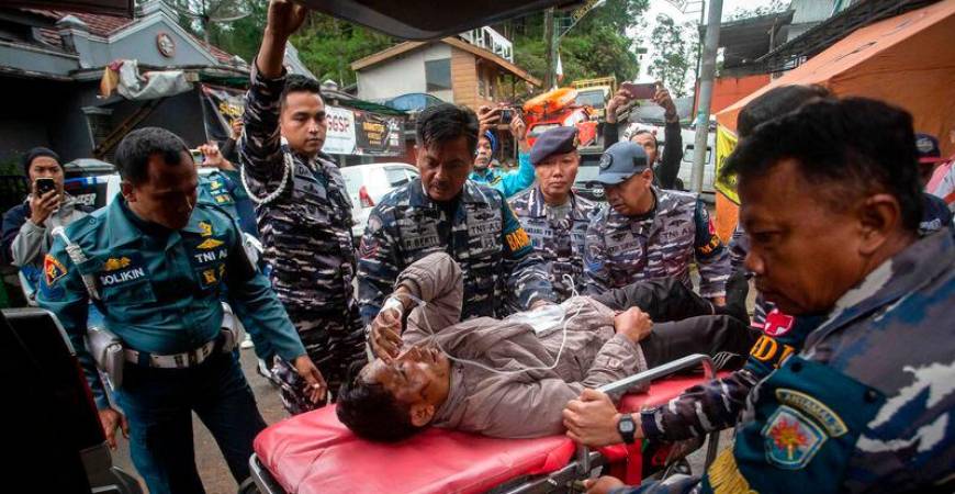 Rescue personnel transport a survivor, from the site of a landslide triggered by heavy rains, to a hospital in Mudal village, near Pekalongan city in Central Java - AFPpix