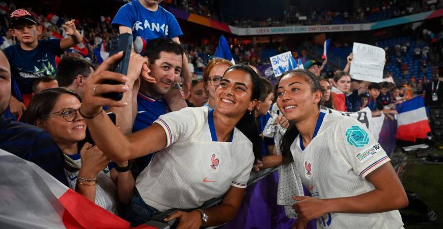 France’s defender #13 Selma Bacha (R) poses for a selfie as she celebrates her team’s victory with fans at the end of the UEFA Women’s Euro 2025 Group D football match between The Netherlands and France at the St. Jakob-Park Stadium in Basel, on July 13, 2025. Photo by Miguel MEDINA / AFP