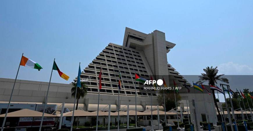 Flags fly in front of the hotel where the upcoming Arab-Islamic summit, organised to discuss the recent Israeli attack on Qatar will take place, in Doha on September 14, 2025. (Photo by MAHMUD HAMS / AFP)