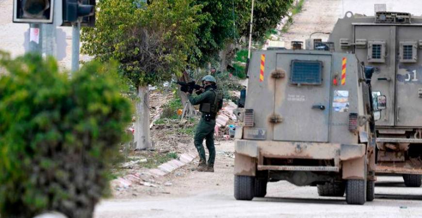 An Israeli soldier takes aim at the entrance of the occupied West Bank refugee camp of Tulkarem, during an ongoing military raid - AFPpix