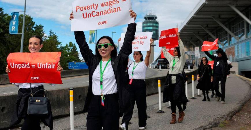Demonstrators hold placards on the day the strike begins, after the union representing more than 10,000 of Air Canada’s flight attendants failed to reach an agreement with the airline, at Vancouver International Airport in Richmond, British Columbia, Canada, August 16, 2025. REUTERS/Chris Helgren
