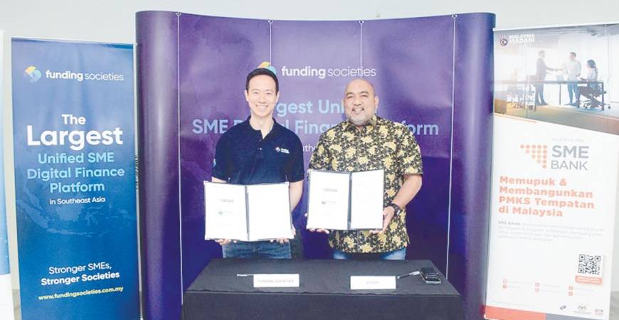 Kah (left) and Hairil Izwar displaying the signed documents.