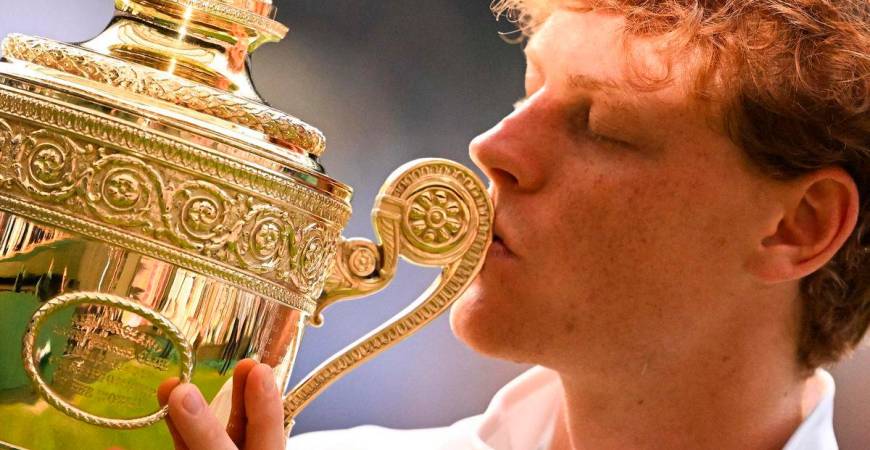 Italy’s Jannik Sinner kisses the winner’s trophy as he poses for pictures following his victory against Spain’s Carlos Alcaraz at the end of their men’s singles final tennis match on the fourteenth day of the 2025 Wimbledon Championships at The All England Lawn Tennis and Croquet Club in Wimbledon, southwest London, on July 13, 2025. - AFP
