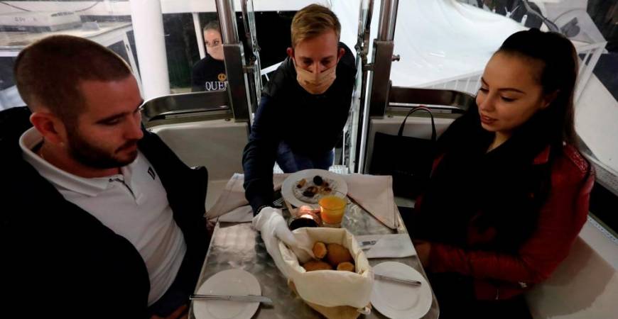 A waiter serves dinner as Michelin-starred restaurant Costes moves into the Budapest Eye ferris wheel during the outbreak of the coronavirus disease (COVID-19), in Budapest, Hungary, October 17, 2020. Picture taken October 17, 2020. REUTERS/Bernadett Szabo